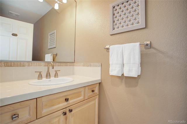 bathroom featuring vanity and backsplash