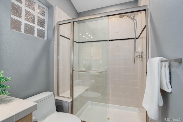 bathroom featuring walk in shower, vanity, and toilet