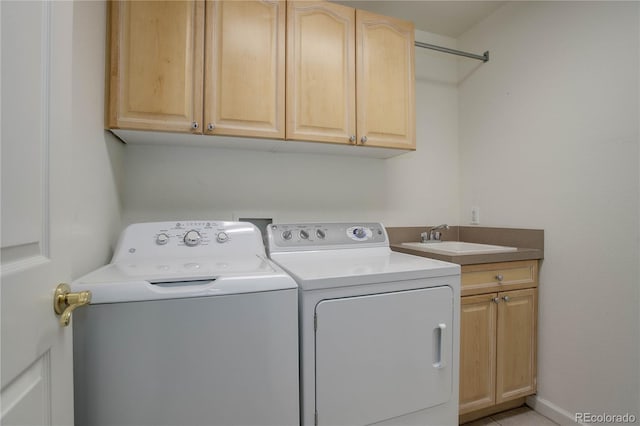 washroom with cabinets, sink, and washer and dryer