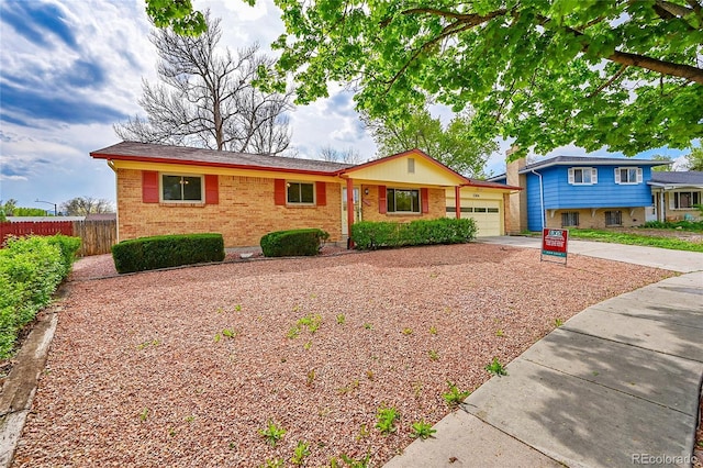 1304 De Reamer Cir, Colorado Springs, CO 80915 - view of front of property featuring brick siding, driveway, a garage, and fence