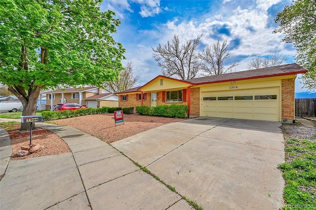 1304 De Reamer Cir, Colorado Springs, CO 80915 - ranch-style home with brick siding, an attached garage, concrete driveway, and fence