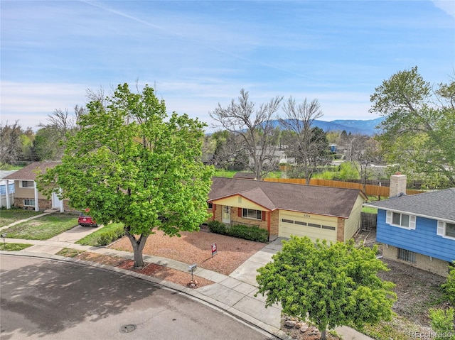 1304 De Reamer Cir, Colorado Springs, CO 80915 - view of front facade with a garage, fence, a mountain view, and concrete driveway