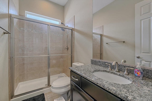 full bathroom with a stall shower, toilet, tile patterned floors, vanity, and a textured wall