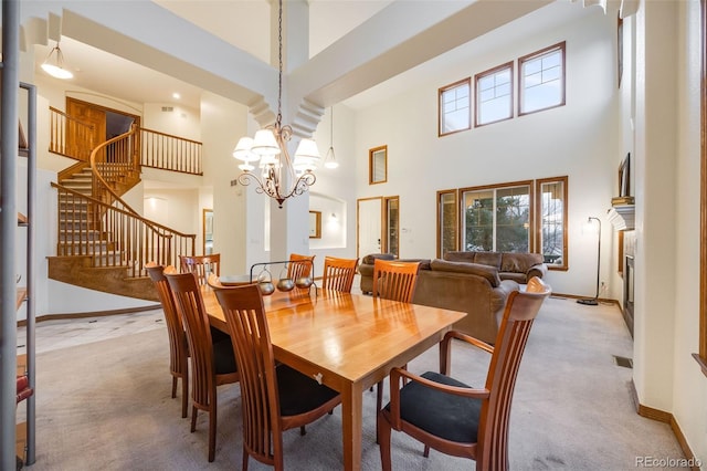 dining area with baseboards, light colored carpet, stairs, a high ceiling, and an inviting chandelier