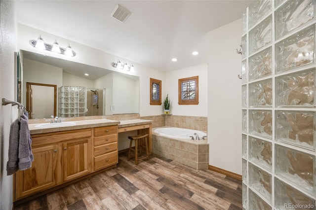 bathroom with vanity, wood finished floors, visible vents, walk in shower, and a garden tub