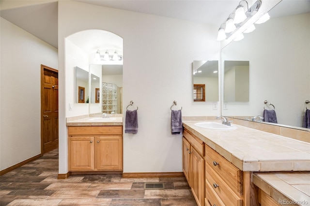 full bathroom featuring visible vents, baseboards, wood finished floors, and vanity