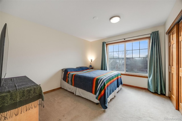 bedroom featuring baseboards and light carpet