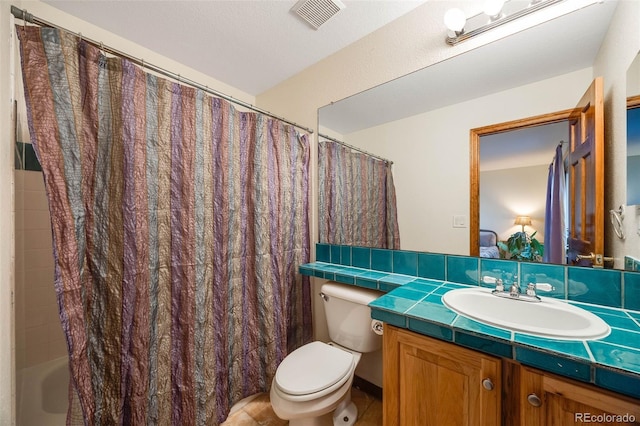 bathroom featuring vanity, toilet, and visible vents