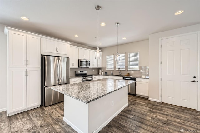 kitchen featuring stainless steel appliances, a sink, white cabinetry, dark wood-type flooring, and recessed lighting