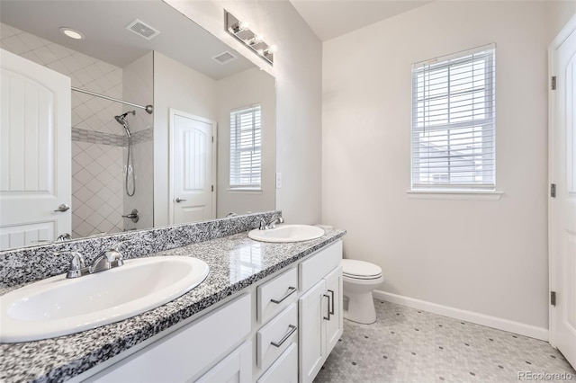 full bath featuring tile patterned floors, baseboards, tiled shower, double vanity, and toilet