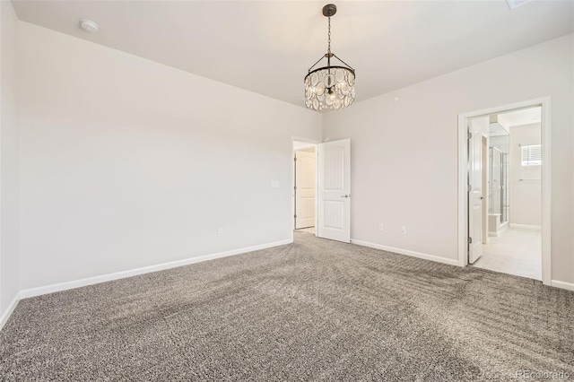 carpeted spare room featuring a chandelier, baseboards, and a smoke detector