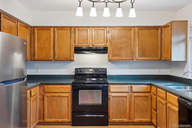 kitchen featuring black appliances, under cabinet range hood, a sink, and dark countertops