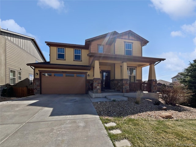 craftsman house featuring an attached garage, driveway, covered porch, and stone siding