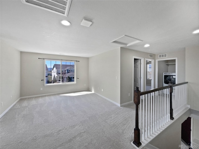 interior space with visible vents, baseboards, attic access, and carpet floors