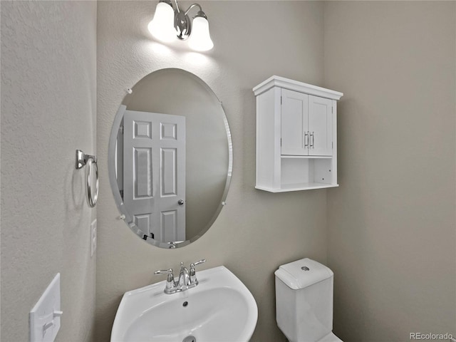 half bath featuring a sink and toilet
