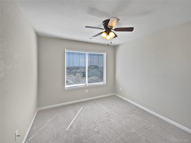 empty room with visible vents, baseboards, a ceiling fan, and carpet