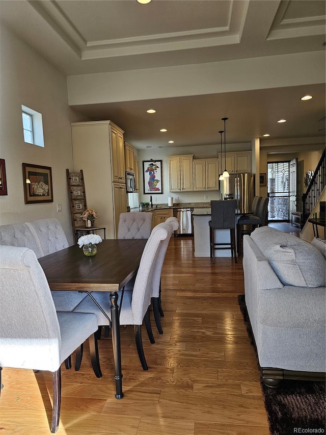 dining area featuring hardwood / wood-style floors, a tray ceiling, and a wealth of natural light