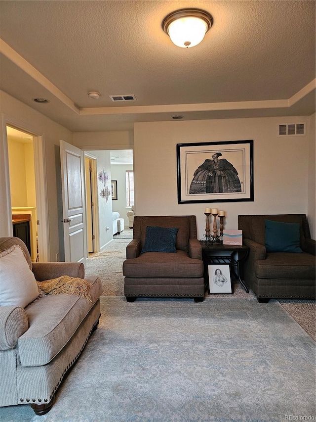 carpeted living room featuring a textured ceiling