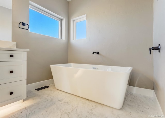 bathroom featuring vanity and a bath