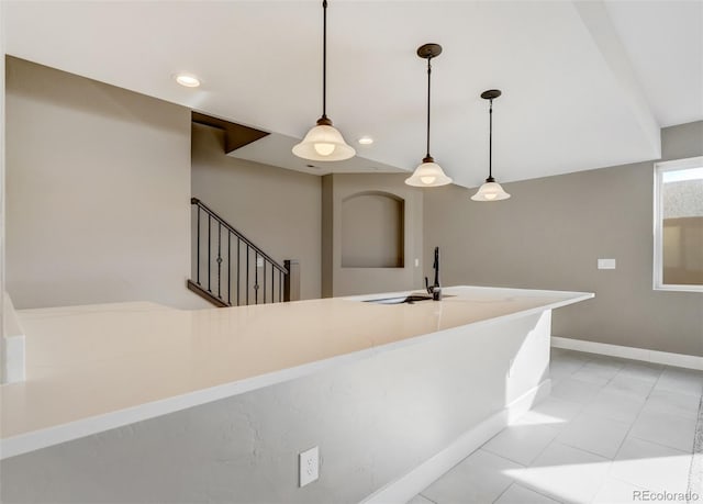 kitchen featuring light tile patterned flooring, sink, and hanging light fixtures