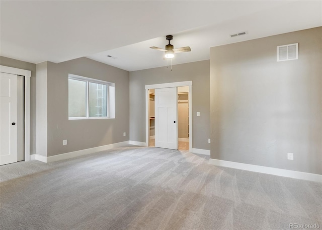 unfurnished bedroom featuring ceiling fan, a closet, and light carpet