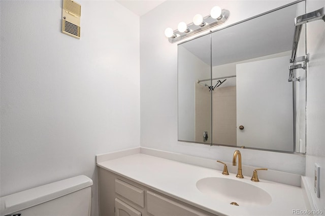 bathroom featuring vanity, toilet, a shower, and visible vents