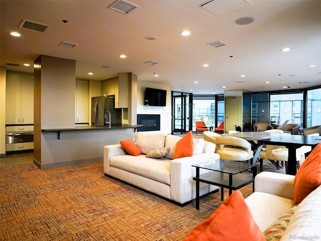 living area featuring carpet flooring, recessed lighting, and visible vents