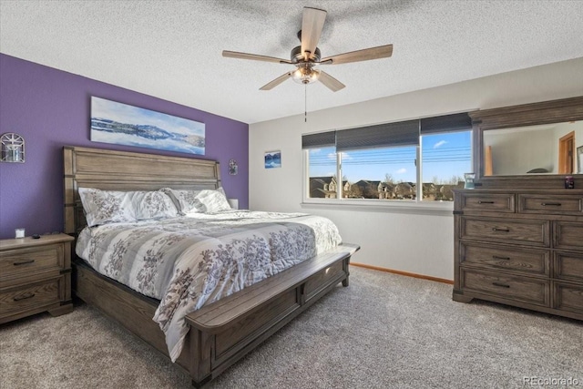 bedroom with ceiling fan, carpet floors, baseboards, and a textured ceiling