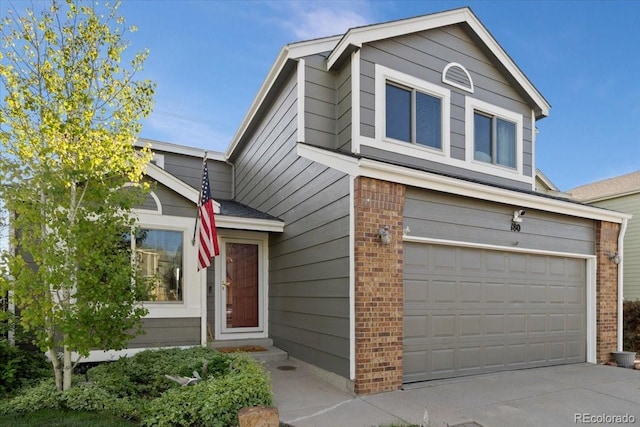 180 S Carlton St, Castle Rock, CO 80104 - view of front facade featuring a garage, brick siding, and driveway
