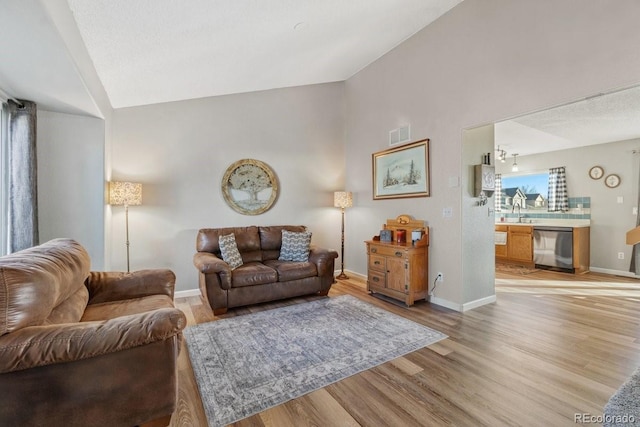 180 S Carlton St, Castle Rock, CO 80104 - living room with vaulted ceiling, light wood finished floors, and baseboards