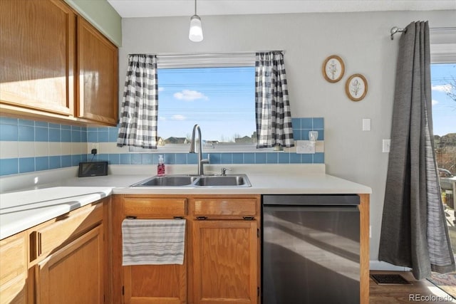 180 S Carlton St, Castle Rock, CO 80104 - kitchen featuring dishwasher, a sink, light countertops, brown cabinetry, and pendant lighting