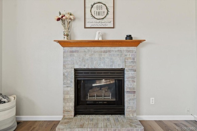 180 S Carlton St, Castle Rock, CO 80104 - detailed view of wood finished floors, a brick fireplace, and baseboards