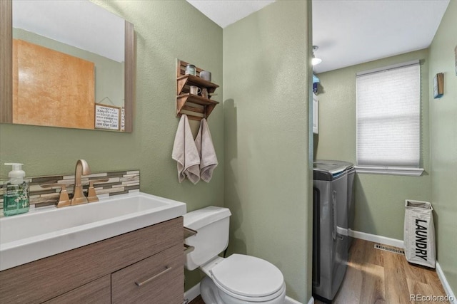 180 S Carlton St, Castle Rock, CO 80104 - bathroom featuring washer / clothes dryer, toilet, vanity, wood finished floors, and baseboards