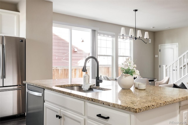 kitchen featuring white cabinetry, sink, light stone countertops, and appliances with stainless steel finishes