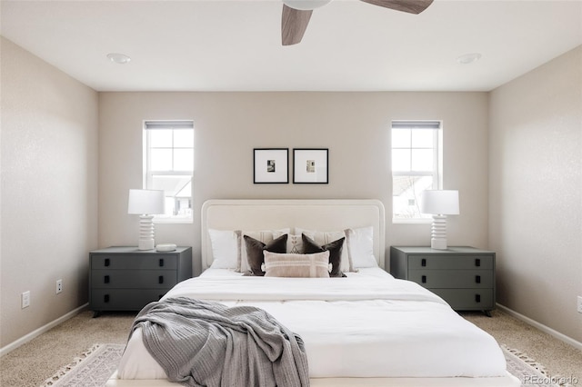 carpeted bedroom featuring multiple windows and ceiling fan