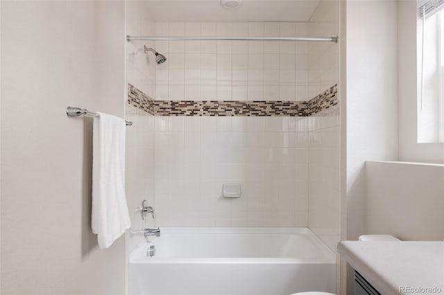 full bathroom featuring vanity, tiled shower / bath, and toilet