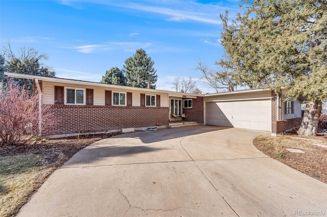 ranch-style home featuring concrete driveway, brick siding, and an attached garage