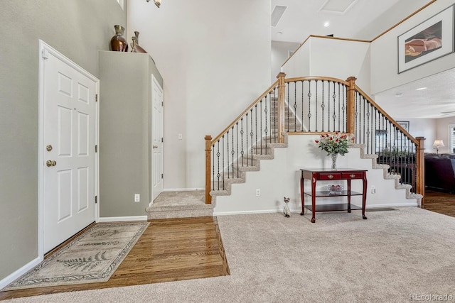 carpeted foyer entrance featuring a high ceiling