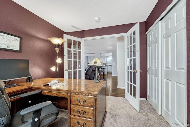 carpeted home office with french doors