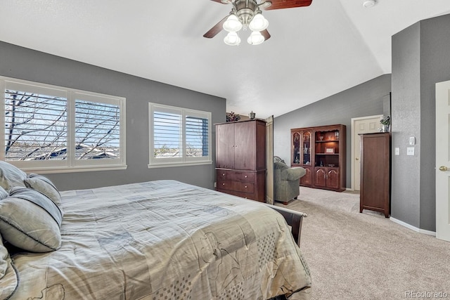 carpeted bedroom with ceiling fan and vaulted ceiling