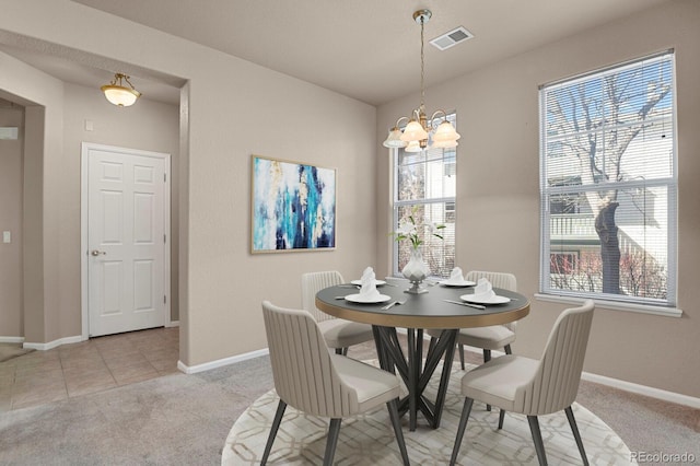 dining room with a chandelier and light colored carpet