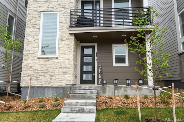 11350 W Grand Ave, Littleton, CO 80127 - entrance to property featuring a balcony and stone siding