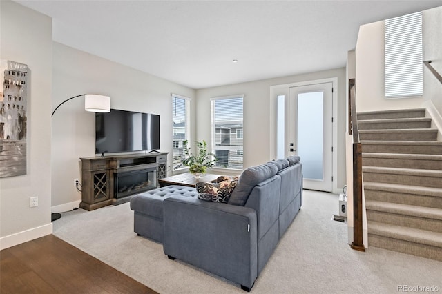 11350 W Grand Ave, Littleton, CO 80127 - living area featuring wood finished floors, baseboards, a glass covered fireplace, and stairs