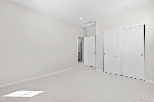 unfurnished bedroom with a closet and light carpet