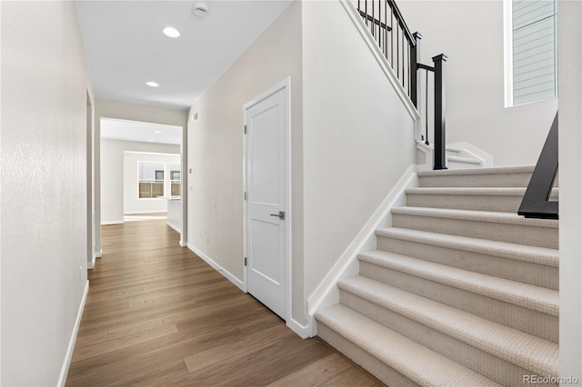 stairs featuring hardwood / wood-style floors