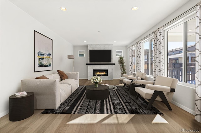 living room featuring light hardwood / wood-style flooring and a high end fireplace