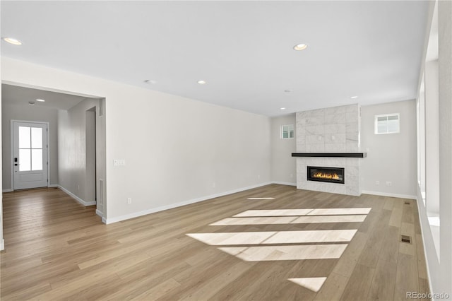 unfurnished living room with a fireplace and light hardwood / wood-style flooring