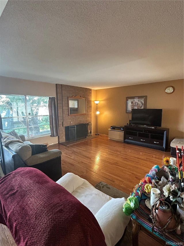 3548 S Hillcrest Dr Unit 2, Denver, CO 80237 - living area featuring a textured ceiling, wood finished floors, and a brick fireplace