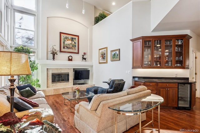 living room featuring dark hardwood / wood-style floors, a towering ceiling, and beverage cooler