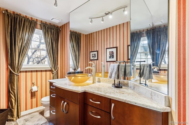 bathroom featuring vanity, rail lighting, and toilet